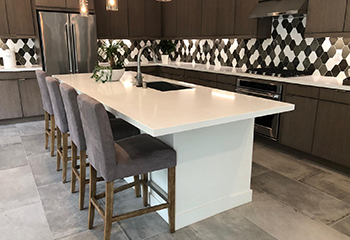 Custom kitchen island with quartz countertop and integrated seating in Tarzana home.